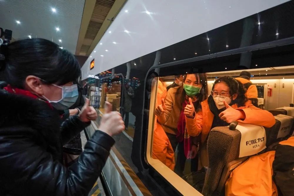 去年1月25日，送站亲友在铁路南京南站站台为首批江苏援湖北医疗队队员打气加油。新华社记者 李博 摄